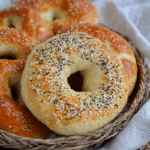 6 golden brown sourdough discard bagels recipe on a ceramic plate
