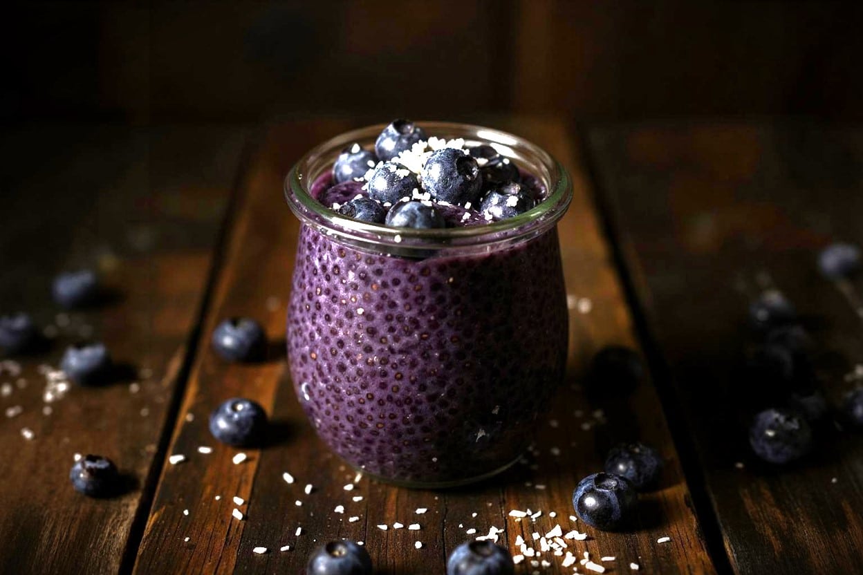 glass jar of blueberry chia pudding with spoon